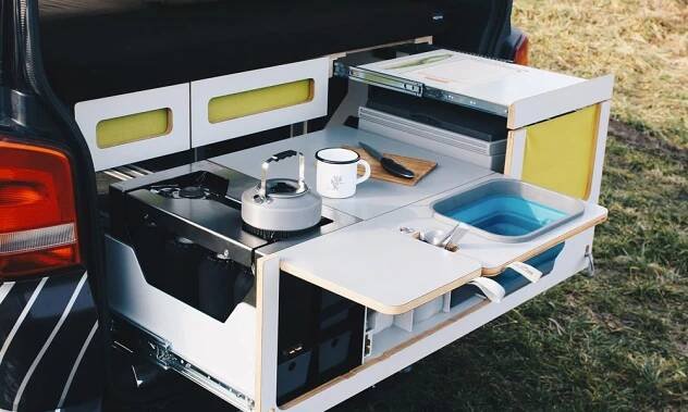 the back end of a van with an open bed and trays in it's trunk
