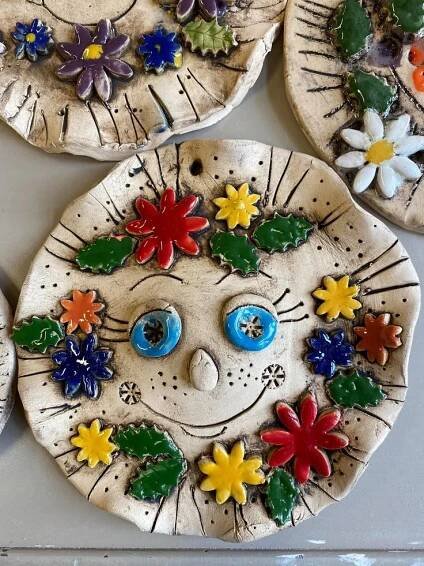four ceramic plates with flowers and leaves on them, all decorated in different shapes and sizes