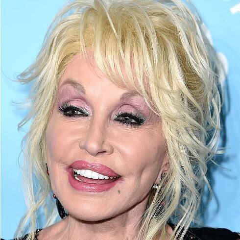 Dolly parton wears light purple eyeshadow and soft pink lipstick 