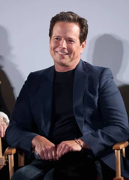 Scott Wolf sitting down and smiling.