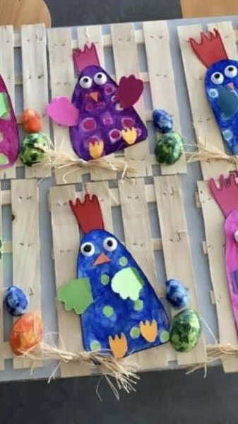 paper mache birds are sitting on wooden pallets