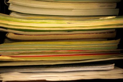 Old research papers stacked for inspiration - Research Paper Thesis Examples