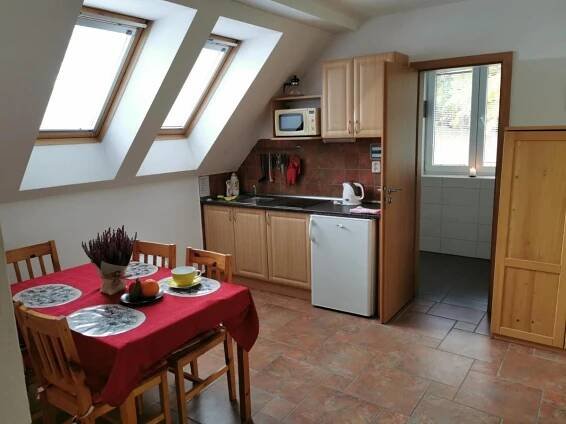 a kitchen with a table with a red table cloth at Penzion Mia in Dolní Moravice