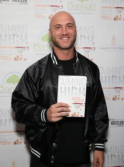 Nick Hogan at a book release event, holding "Aiming High."