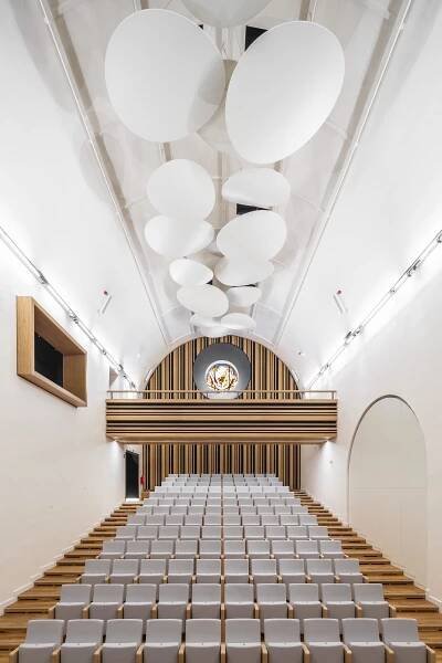 Dechberoucí proměna bývalého kostela na sál Jihočeské filharmonie. Moderní minimalismus a netradiční barvy