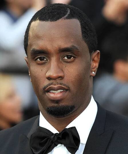 Sean Combs smiles slightly while wearing a tuxedo.