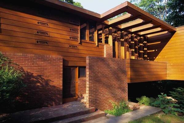 Entrance to modern brick and wood house, stairs located behind wall