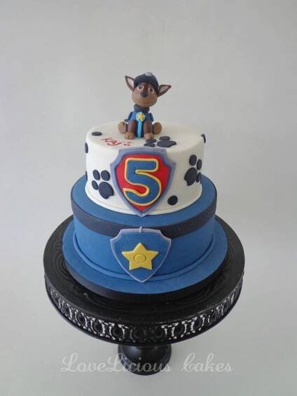 a three tiered cake decorated with a dog and number five on it's side
