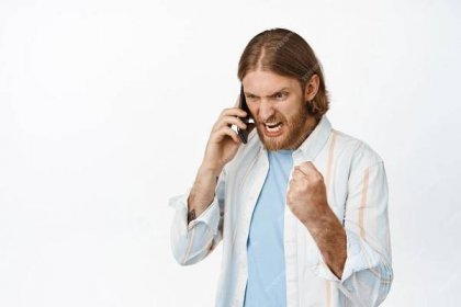 Free photo image of angry blond bearded man cursing on phone call, screaming during conversation on mobile, shouting upset, standing against white background.