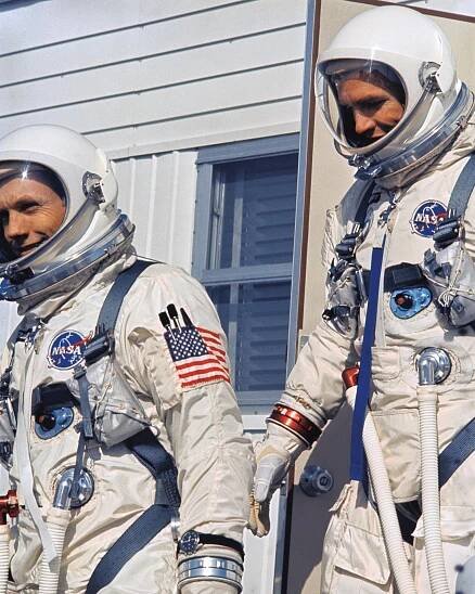 Gemini 8 astronauts Neil Armstrong and Dave Scott descend the stairs of the suiting trailer wearing their Gemini space suits.