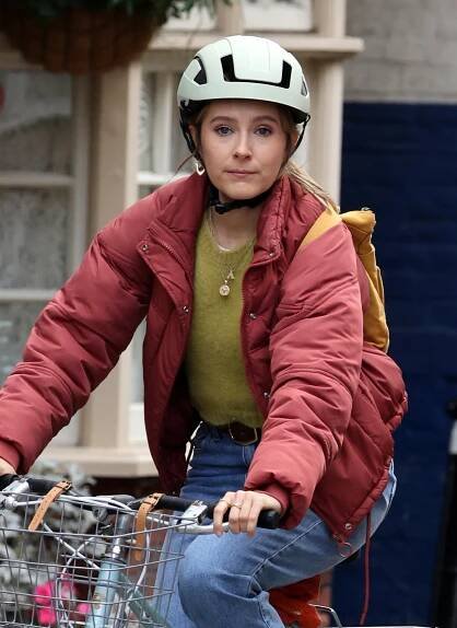 a woman wearing a helmet is riding a bike