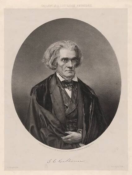 A black and white portrait of an older man with wavy gray hair, wearing a suit with a bow tie and a draped cloak, looking slightly to the viewer’s left. The image has a formal, historical appearance.