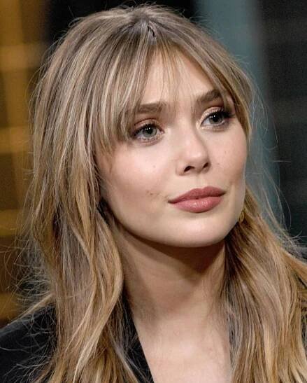 a close up of a person with long hair wearing a black jacket and red lipstick