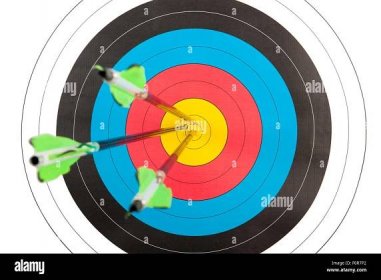 The bull's eye of an archery target hit by three arrows Stock Photo