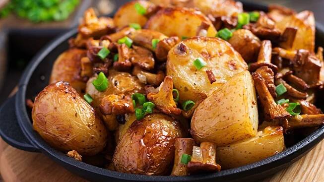 Baked potatoes with garlic herbs fried chanterelles cast iron skillet