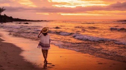 Sestra se při západu slunce prochází po pláži a pozoruje vlny