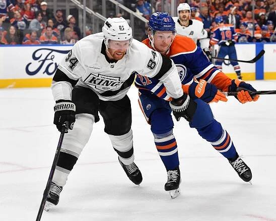 Los Angeles Kings player #84 battling Edmonton Oilers player #21 for the puck.