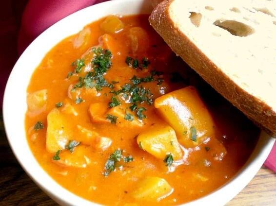 a bowl of soup with bread on the side