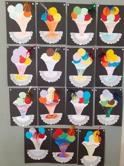 the ice cream sundaes are cut out and hung on the wall with paper