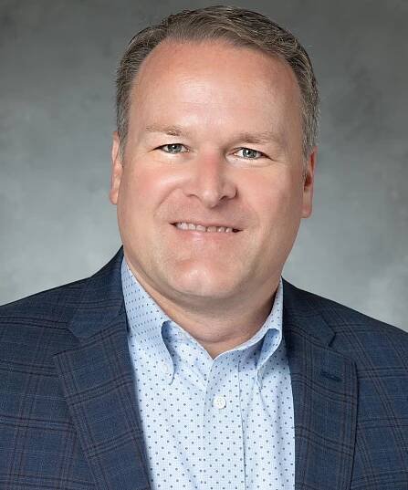 Paul wearing a blue & plaid blazer posing for his leadership portrait