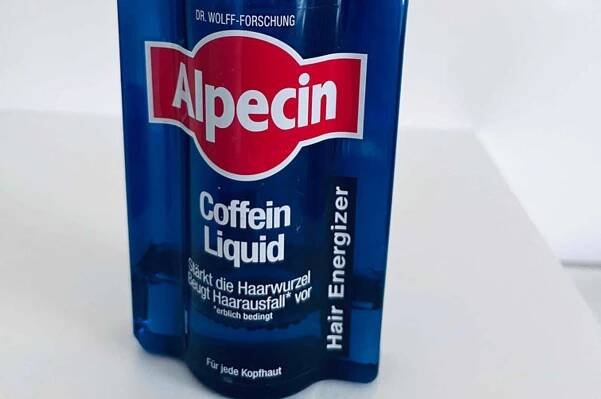 Im Test: Eine Flasche Alpecin ohne Deckel auf einer weißen Oberfläche.