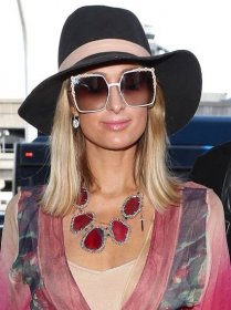 Paris Hilton over-accessorized with a black, wide-brimmed hat, Fendi "White Can Eye" embellished sunglasses, and a massive Kendra Scott "Ava" pink agate necklace