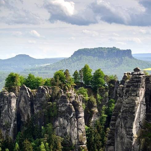 Blick von einem Felsen in der Nationalparkregion Sächsische Schweiz zur Bastei, im Hintergrund erhebt sich der Lilienstein.