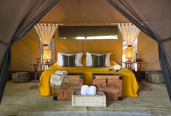 Interior of tent at Lale's Camp in Ethiopia's Omo Valley, with mustard yellow textiles