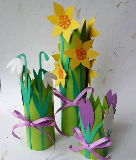 some paper flowers are sitting in vases