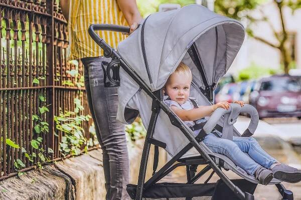 Kleinkind in Kinderwagen grau