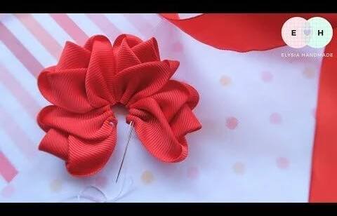 a close up of a red bow on a piece of paper with polka dot fabric
