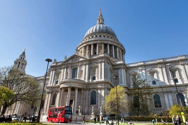 St. Paul's Cathedral in London with a red double-decker bus in front.