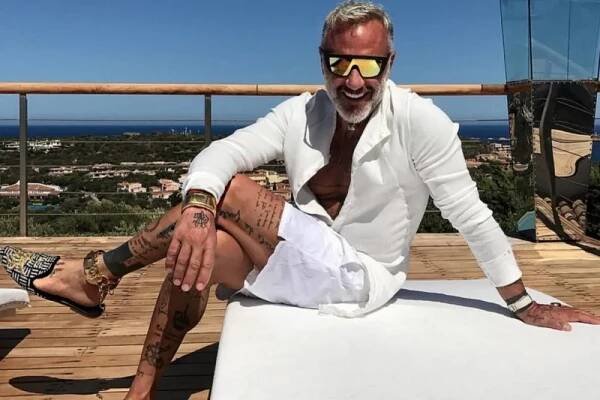Fashionable man lounges outdoors, embodying Italian style.