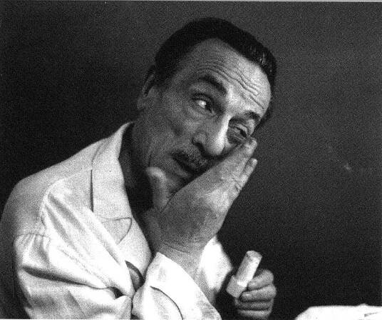 Close up of Eduardo De Filippo applying cosmetics on his faces wearing a white pijama in black and white in Italy
