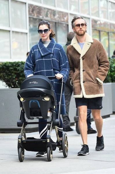 Anne Hathaway pushing a stroller alongside Adam Shulman