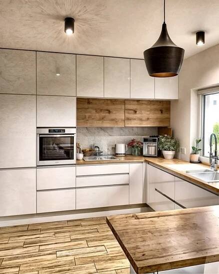 a kitchen with white cabinets and wooden counter tops next to a large window that looks out onto the outdoors