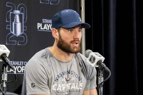 Tom Wilson speaking into a microphone