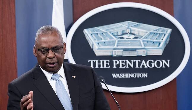 US Secretary of Defense Lloyd Austin III speaks into a microphone in front of the Pentagon logo.