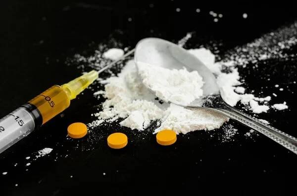 Drogové stříkačka a vařené heroinu na lžičku s amfetaminem. — Stock obrázek