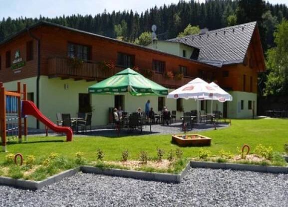 a house with a yard with a playground with a slide at Wellness hotel Sauna in Malá Morávka