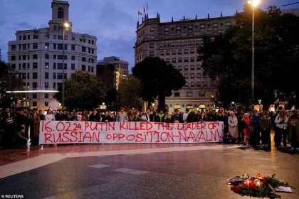 People hold a banner during a protest, following the death of Russian opposition leader Alexei Navalny, at the Catalunya square, Barcelona, Spain