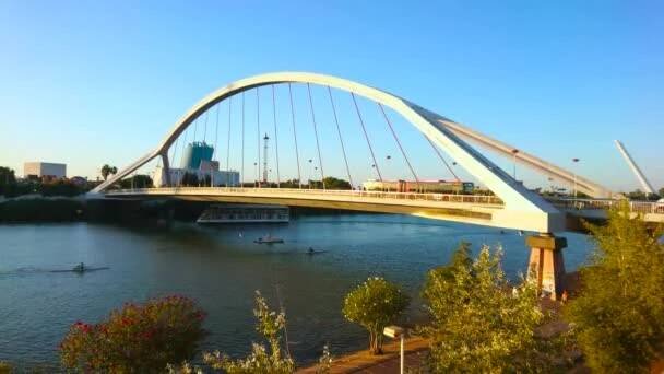 SEVILLE, ŠPANĚLSKO - 1. října 2019: Moderní most Barqueta přes řeku Guadalquivir s dopravou, projíždějící po mostě a lodích, plovoucí řekou, 1. října v Seville — Stock záběr