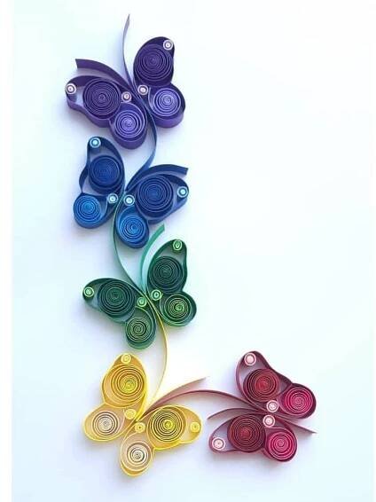 three colorful paper butterflies on a white background