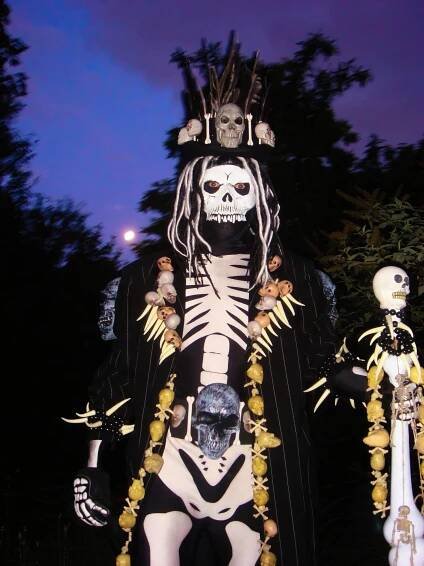 Stilt-walking skeleton spider and voodoo priest.