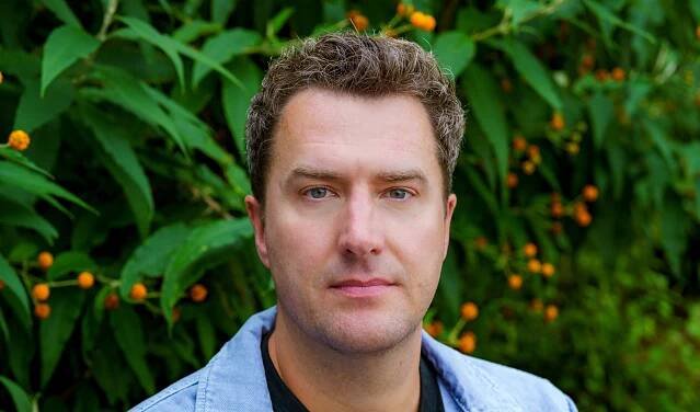 Portrait of Mark Bowden under some lights