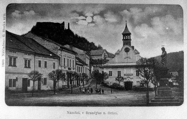 Brandýs nad Orlicí, východní strana náměstí se starou radnicí a zříceninou hradu v pozadí; před rokem 1905 (sbírka Jiřího Fiedlera).