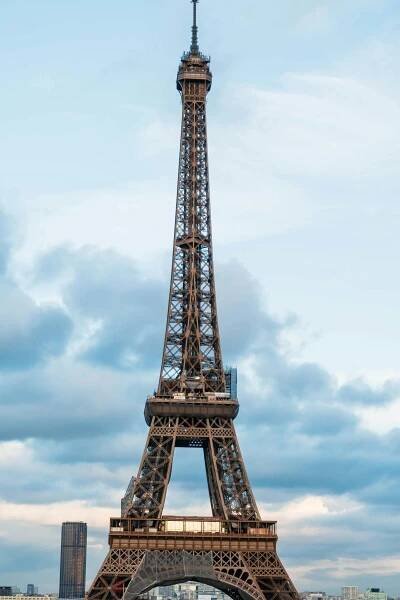 Free Vertical shot of the Eiffel Tower framed against a cloudy sky in Paris, France. Stock Photo