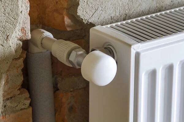 Close-up side view of isolated installed heating radiator on bri
