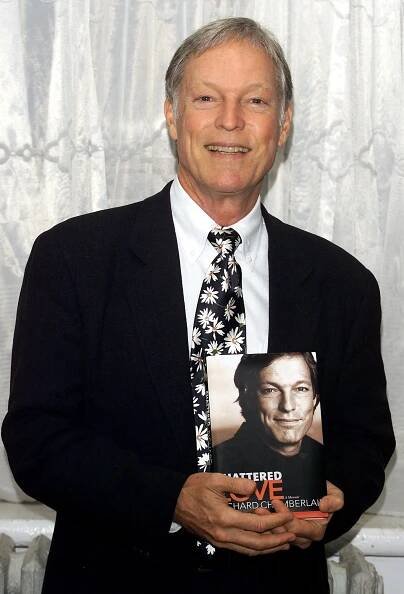 Richard Chamberlain at The Lesbian & Gay Community Services Center in Manhattan, New York, on June 5, 2003, with his book "Shattered Love" | Source: Getty Images