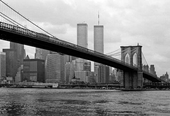 The twin towers of the World Trade Center loom above the Brooklyn Bridge in New York City.